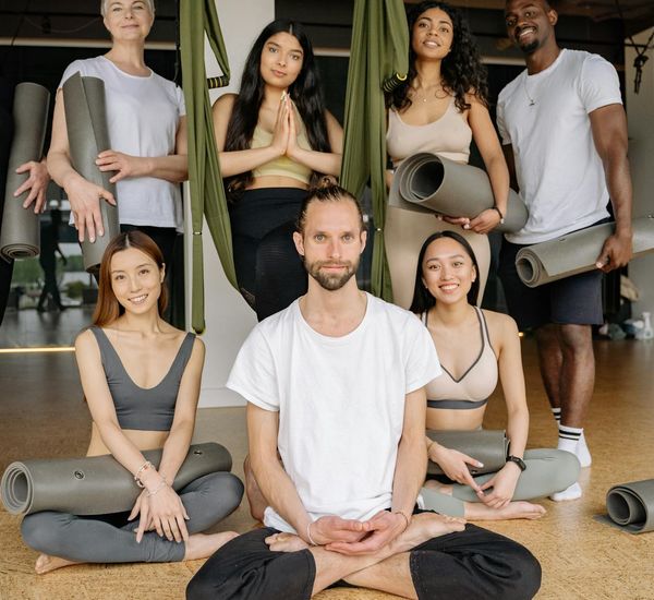 A diverse group of people sitting in a circle during a yoga class.