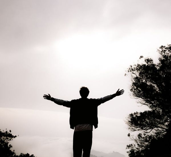 Person meditating peacefully with a calm expression at sunrise.